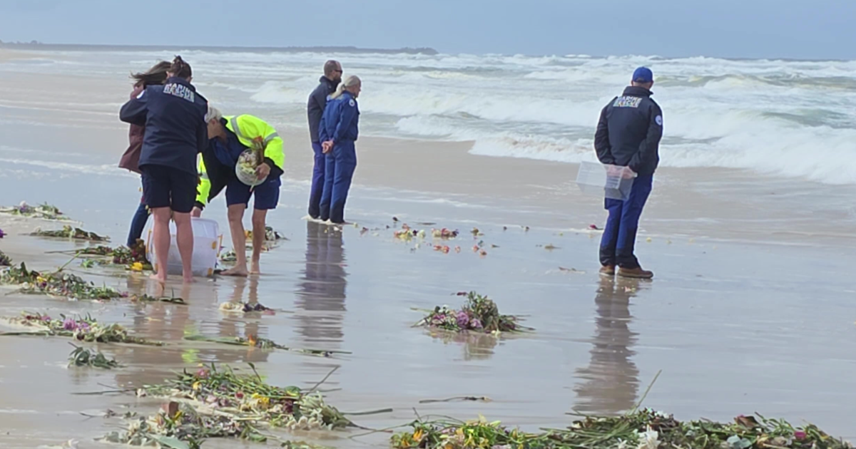 Volunteers and supporters walk along South Ballina Beach during a private ceremony honouring Frank Petsch and Bill Ewen. Photo: Marine Rescue NSW.