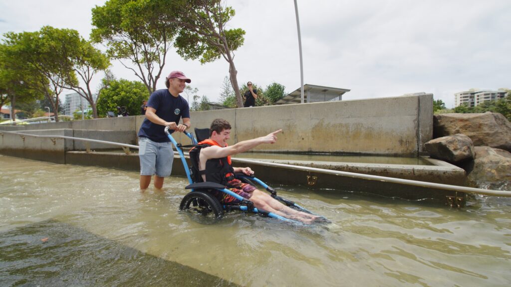 The beach wheelchair can be taken into the water up to the top of its wheels, allowing participants to enjoy the cool conditions. Photo: SUPPLIED