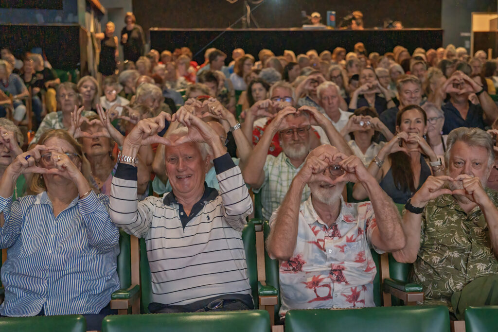 “We love you Jenny.” Supporters form heart shapes with their hands during a tribute event for former Lismore mayor Jenny Dowell. Photo: LYN McCARTHY
