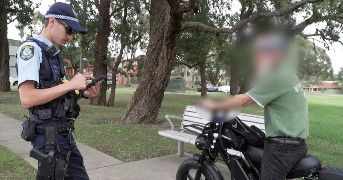 Not just young riders, an older man speaks with police as enforcement targets e-bike riders across all generations. Photo: supplied.