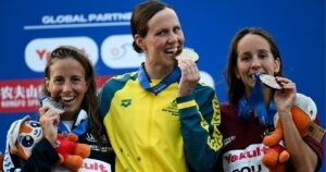 Tweed Heads swimmer Moesha Johnson on the podium after winning gold in the open water swimming women's 10km final at the World Aquatics Championships in Singapore. Photo: AAP